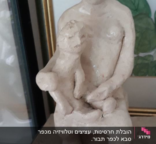 פסל של דמות יושבת עם ילד על ברכיה